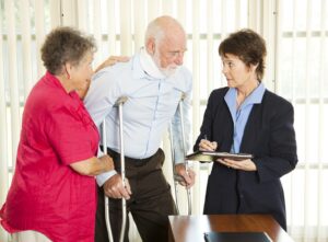 An injury victim on crutches with a neck brace speaking to a personal injury lawyer in Bakersfield, CA