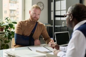 Attorney sits at desk with client and explains the most common results of slip and fall accidents.